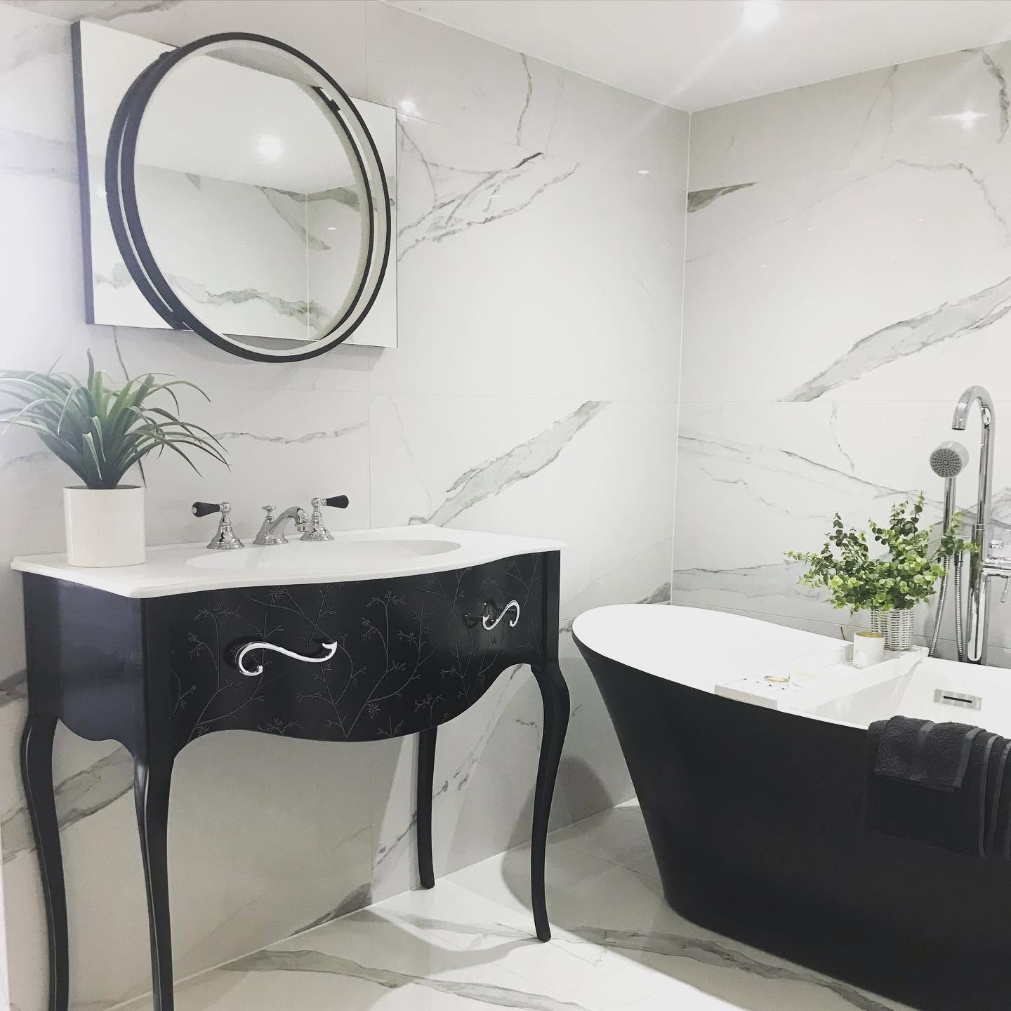 Marble bathroom with black freestanding bath and black vanity unit